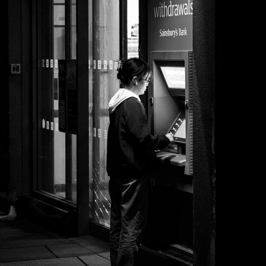 woman standing in front of automated teller machine